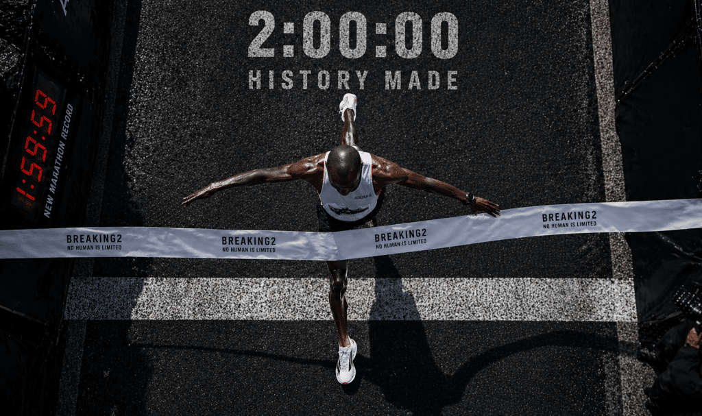 Løber krydser målstregen set ovenfra med moderne maratonsko og verdensrekord under 2 timer